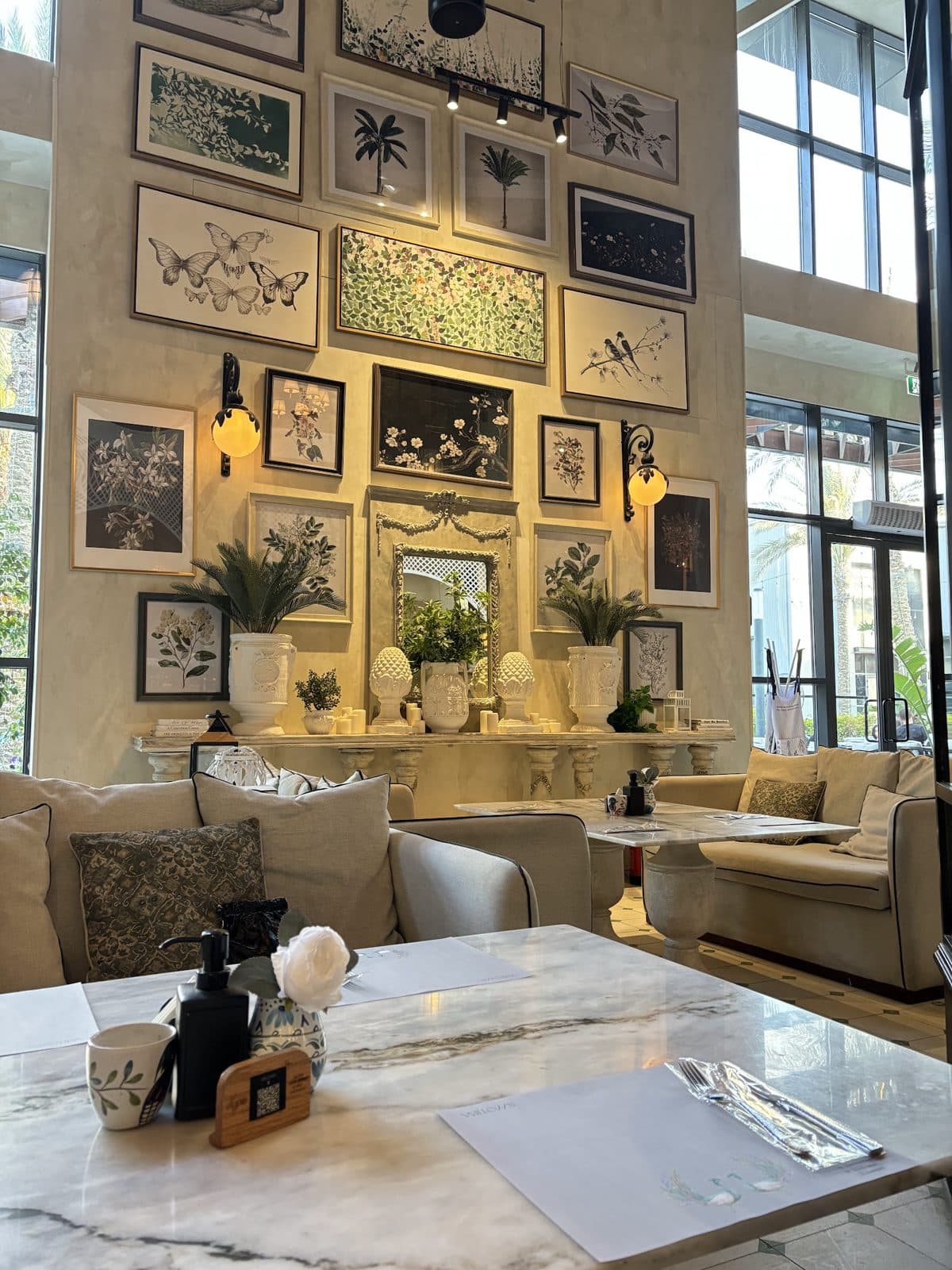 The interior at Willow's District 5, with a gallery wall of framed art above upholstered sofas.